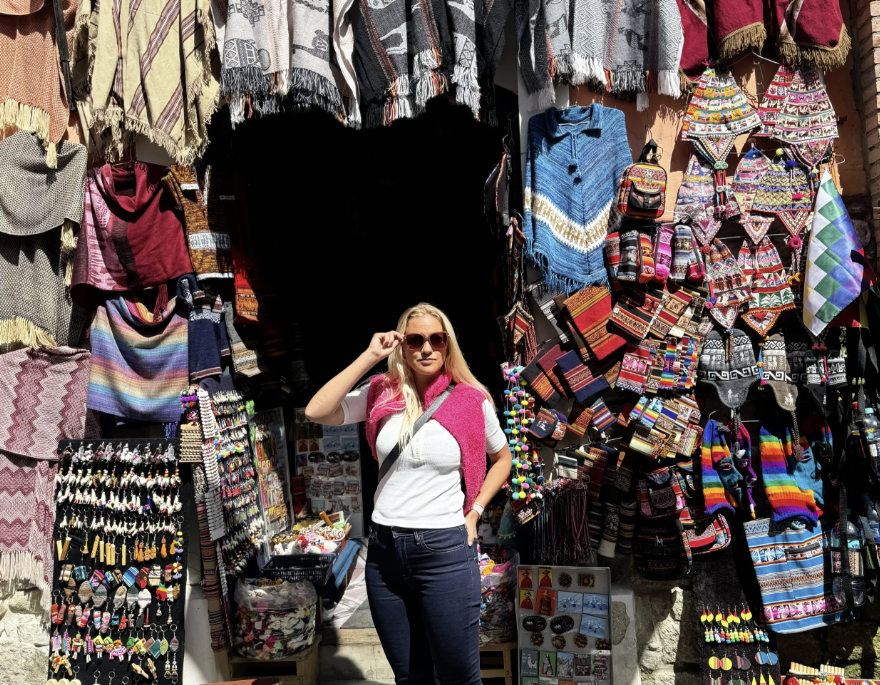 Elin outside a Sagárnaga street stall filled with alpaca knits, ponchos and souvenirs in La Paz