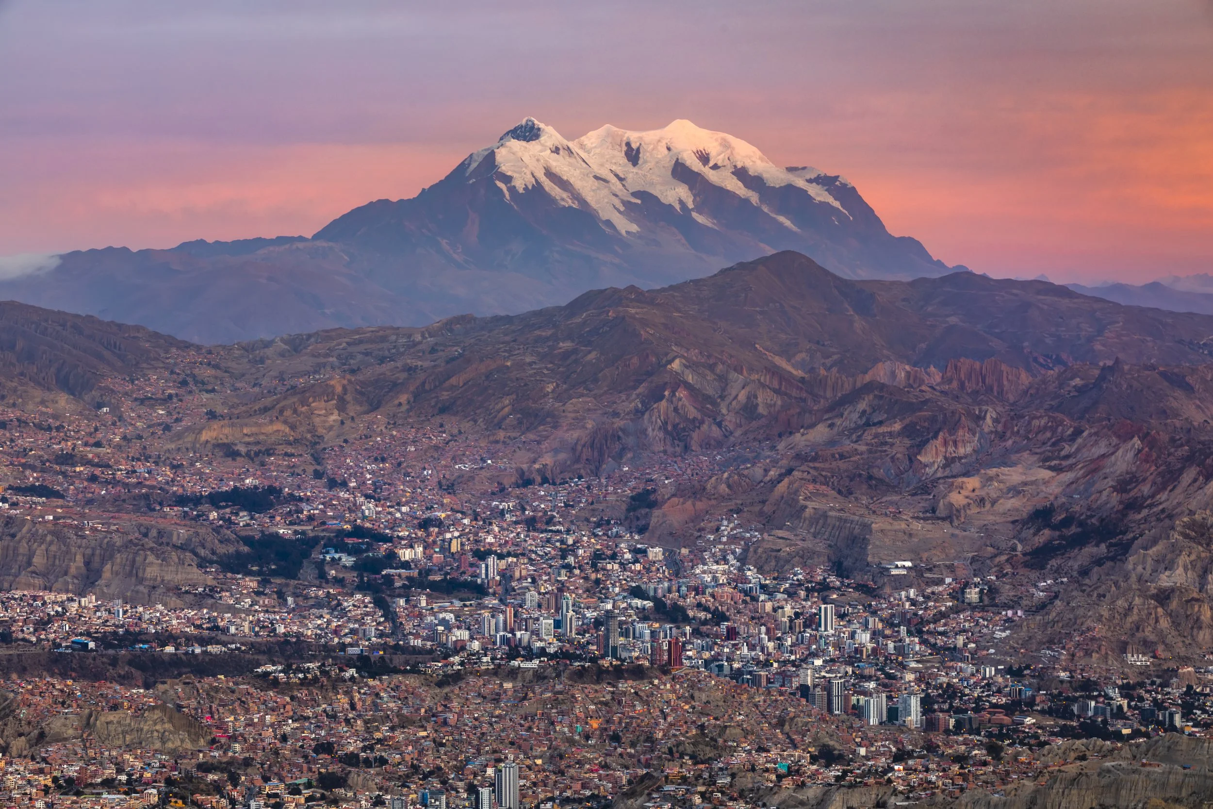 La Paz at sunset with Illimani mountain rising behind the city
