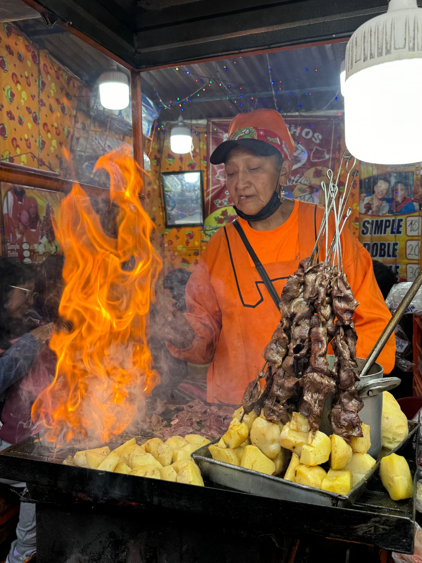 Anticuchos grilling over an open flame at a La Paz street-food stall